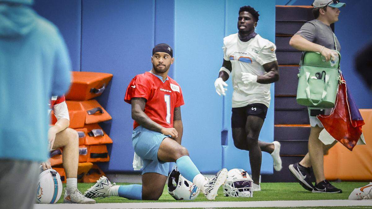 El wide receiver de los Dolphins Tyreek Hill (der.) corre junto al quarterback Tua Tagovailoa  durante la práctica en el Baptist Health Training Complex en Miami Gardens, Florida, el 24 de julio de 2024.