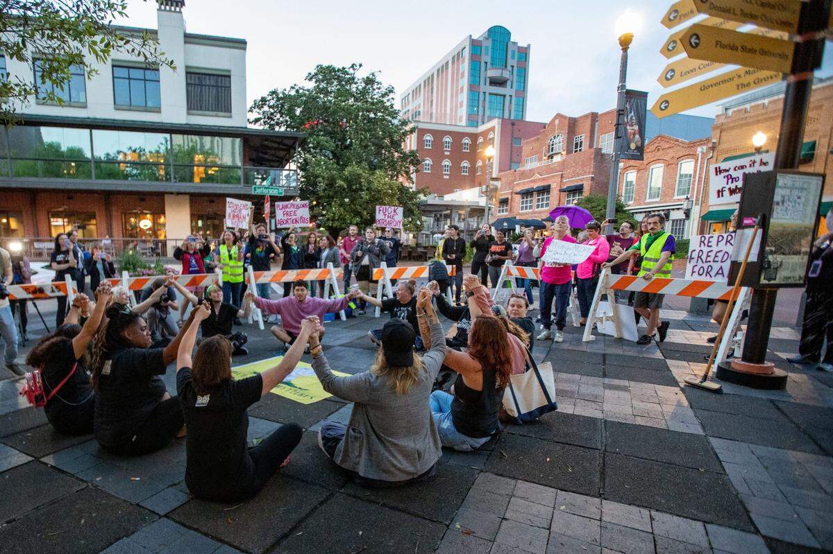 Un grupo de aproximadamente una docena de activistas se sientan en círculo mientras se toman de las manos para protestar contra la ley SB 300, que prohibiría los abortos después de las seis semanas en la Florida, antes de ser arrestados el lunes 3 de abril de 2023.