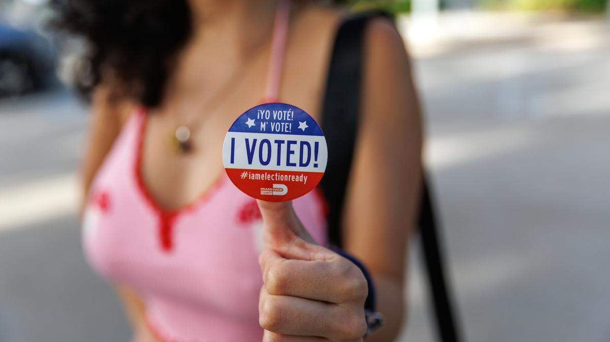 Nicole Montesinos, 23, poses with an “I Voted!” sticker after casting a ballot during the mid-term elections in Miami-Dade County at Northeast Dade-Aventura Branch Library on Tuesday, Nov. 8, 2022, in Aventura, Florida.