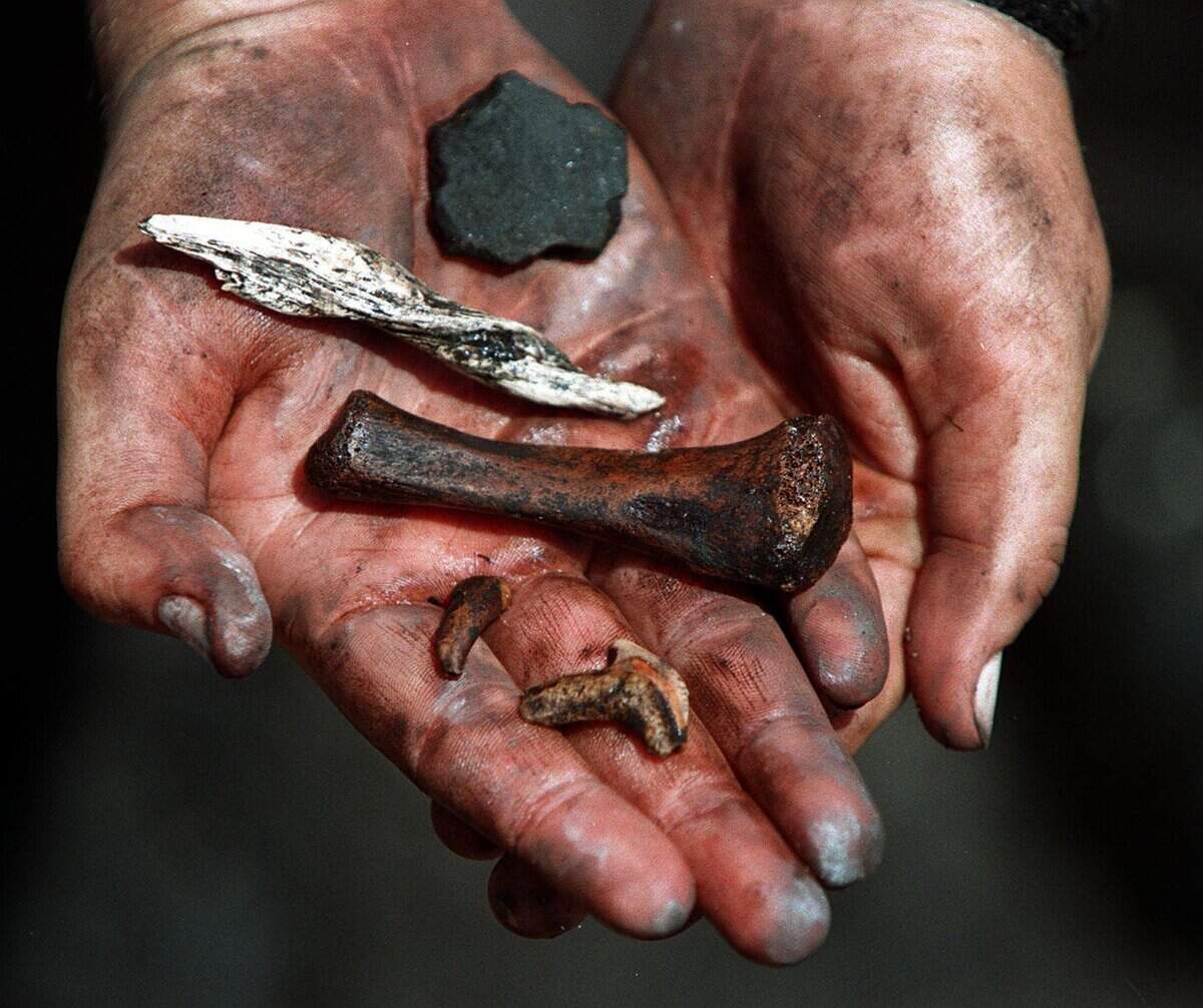 Historic preservation specialist John M. Ricisak holds a sample of prehistoric artifacts found at the site of the 2,000-year-old Miami Circle shortly after its discovery in 1998. From top downward are a pottery shard, a tool made out of conch shell, animal bone, human tooth and a shark’s tooth.