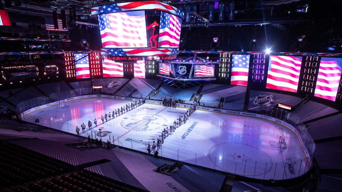 New York Islanders and New York Rangers line up for the national anthem before an NHL hockey exhibition game in Toronto on Wednesday, July 29, 2020.