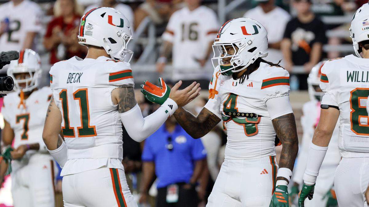 Miami Hurricanes quarterback Carson Beck (11) and running back Mark Fletcher Jr. (4) greet each other on the field before the start of the game against the Florida State Seminoles at Doak Campbell Stadium in Tallahassee, Florida, on Saturday, October 4, 2025.