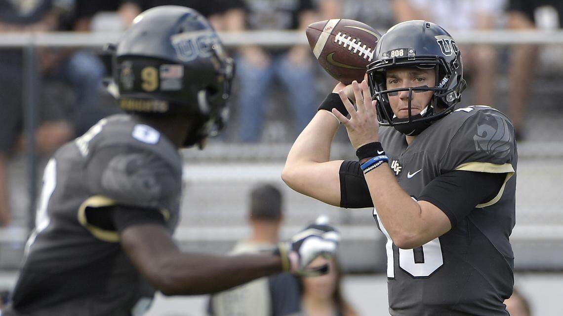 In this Nov. 10, 2018, file photo, Central Florida quarterback McKenzie Milton, right, throws a pass to running back Adrian Killins Jr. (9) during the first half of an NCAA college football game against Navy in Orlando, Fla.