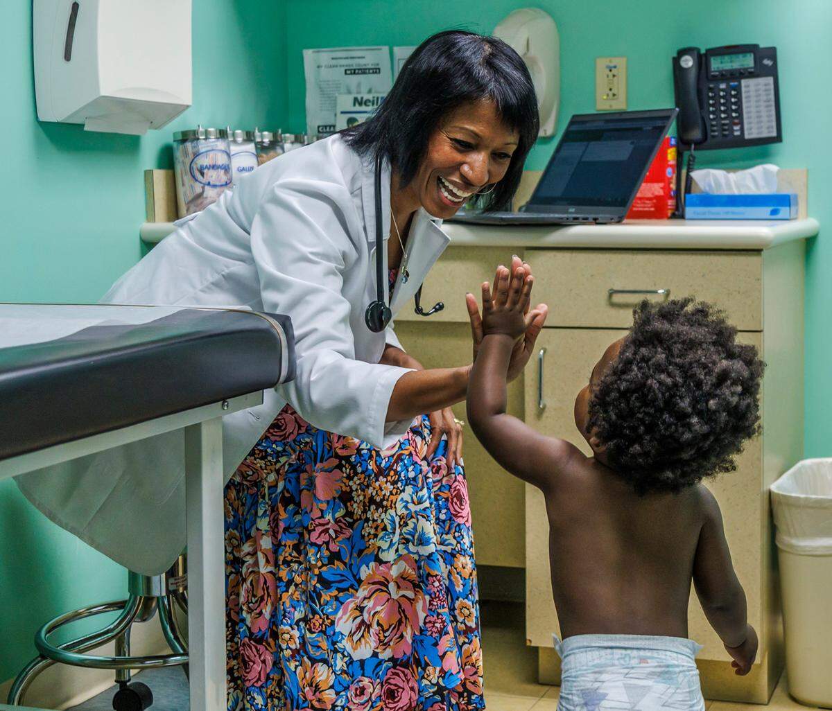 Dr. Tina Carroll-Scott high-fives Dillon Burkhalter, 1, during a visit to her office at the South Miami Children’s Clinic on Wednesday, Oct. 4, 2023, in Miami, Fla.