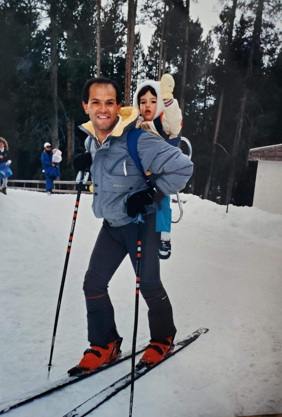 Horacio Asbun carries his infant son, Domenech Asbun, on his back as he skiis.