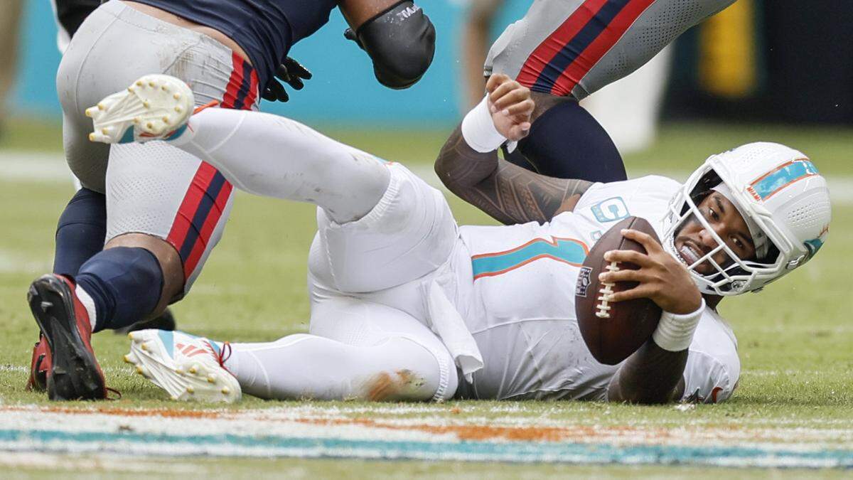 Miami Dolphins quarterback Tua Tagovailoa (1) is sacked in the second half against the New England Patriots during an NFL football game at Hard Rock Stadium in Miami Gardens, Florida, on Sunday, September 14, 2025.