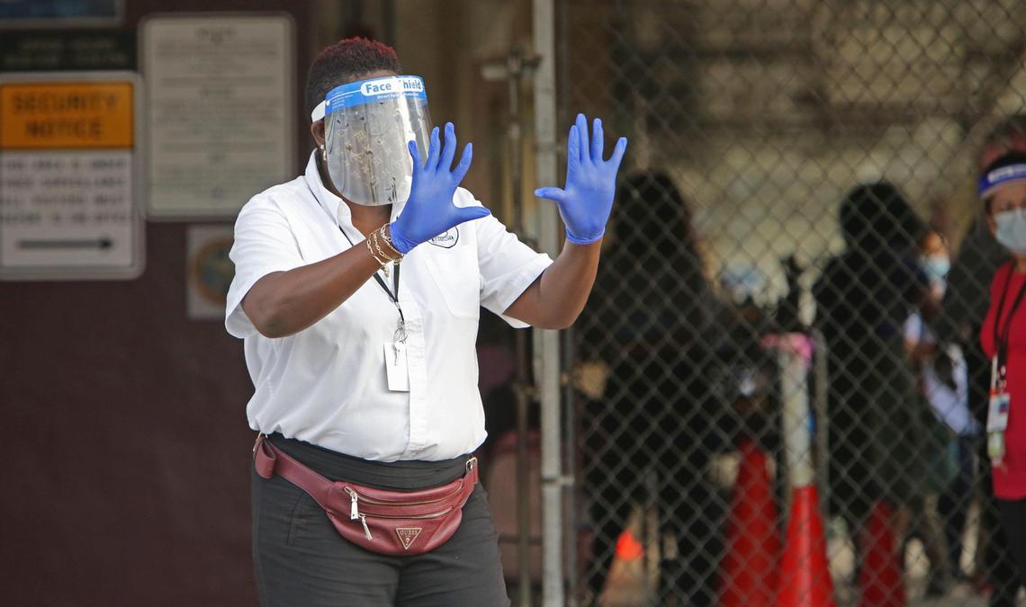 In Miami-Dade County students in Pre-K, Kindergarten and first grade were welcomed back to schools Monday, October 5, 2020. A Miami-Dade Schools security worker puts up her hands to stop parents from entering the grounds with their children at the entrance to Carrie P. Meek/Westview K-8.