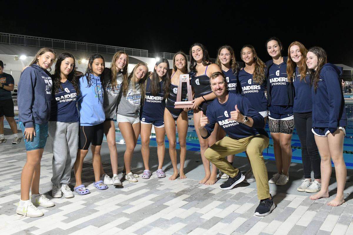 The Gulliver Prep girls team celebrates their Class 2A, District 12 Championship with head coach Nick Folker.