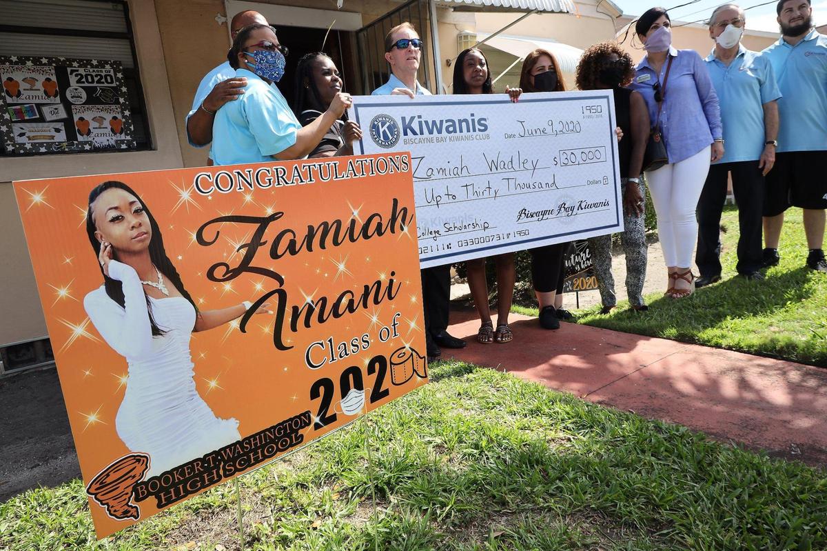 Graduating senior at Booker T. Washington High Zamiah Wadley, center, stands with club members of the Biscayne Bay Kiwanis Club after receiving a surprised scholarship to attend college at Bethune-Cookman University.