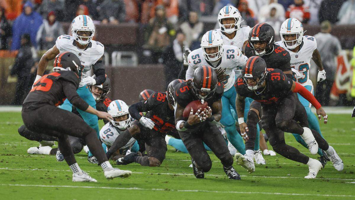 Cleveland Browns safety Rayshawn Jenkins (5) picks up the ball after Miami Dolphins wide receiver Dee Eskridge (82) fumbles on a hit by Cleveland Browns outside linebacker Jerome Baker (17) during the first half of an NFL football game at Huntington Bank Field in Cleveland, Ohio, on Sunday, October 19, 2025. 