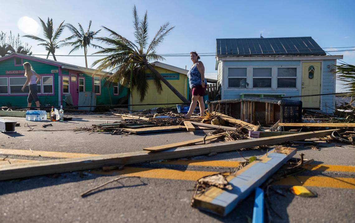 Donna LaMountain, 51, surveys damage on Pine Island Road on Thursday, Sept. 29, 2022, in Matlacha, Florida. Hurricane Ian made landfall on the coast of Southwest Florida as a Category 4 storm the afternoon before, leaving areas affected with flooded streets, downed trees and scattered debris.