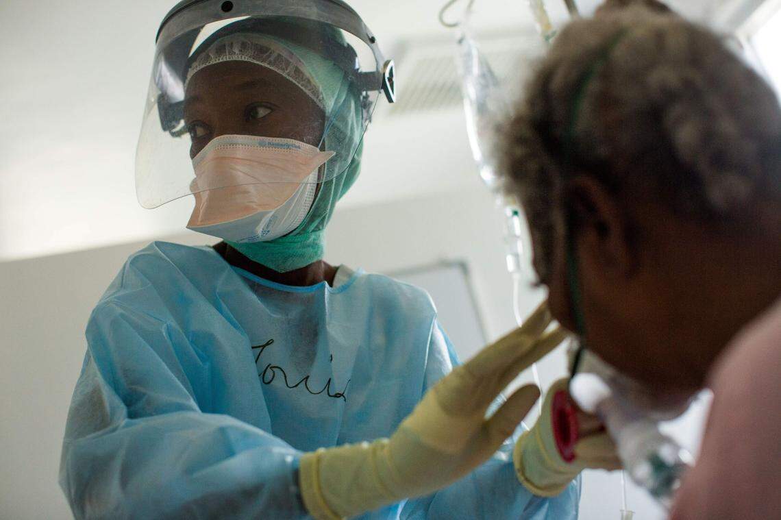 A nurse assists a COVID-19 patient at the Doctors Without Borders Drouillard Hospital in Cite Soleil, Haiti, on June 3, 2020.