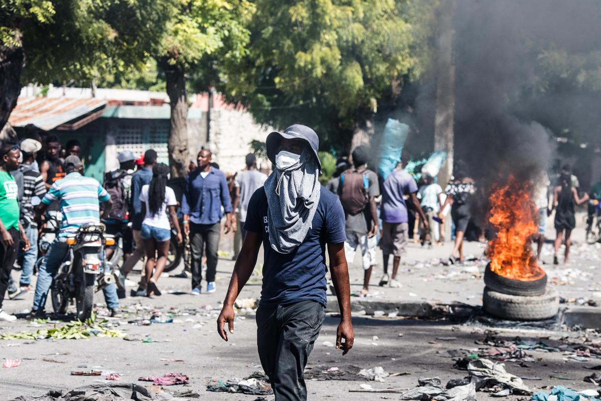 Protesters burn tires as they march in the street demanding the resignation of President Jovenel Moise in the Haitian capital in Port-au-Prince on October 28, 2019.