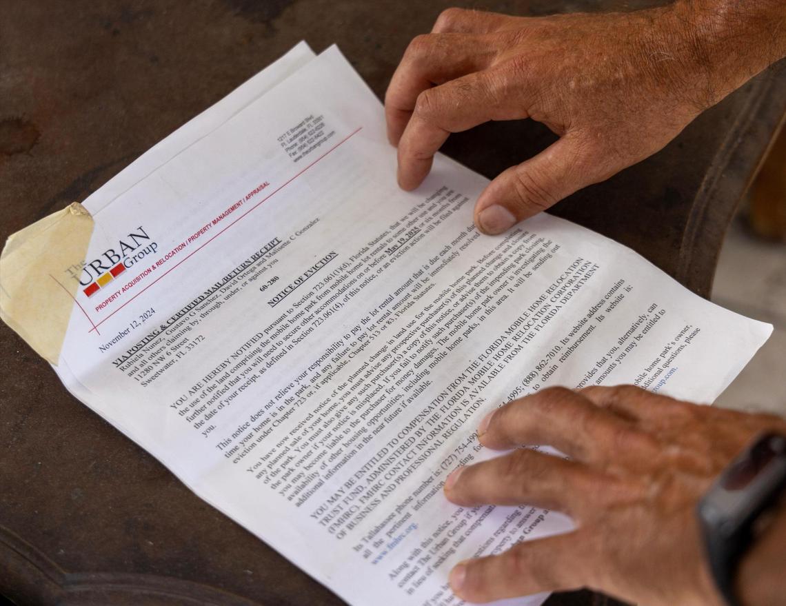 Hamilton Dos Santos reads the notice to vacate outside his mobile home on Thursday, Nov. 14, 2024, in Sweetwater, Florida.