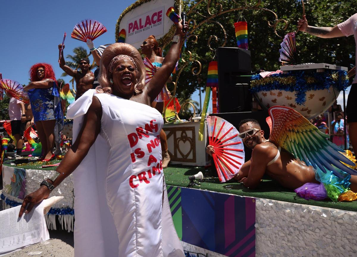 Dressed in drag, the parade MC engages participants as they wave to the crowd on Sunday, April 16, 2023, on Ocean Drive in Miami Beach.