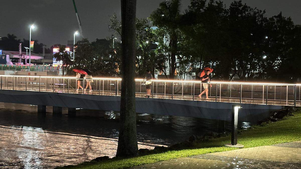 University of Miami students break out the umbrellas on the Lake Osceola bridge Thursday night, Sept. 18, 2025, as steady rains competed with The U’s preparations for Saturday’s ESPN GameDay activities on campus.