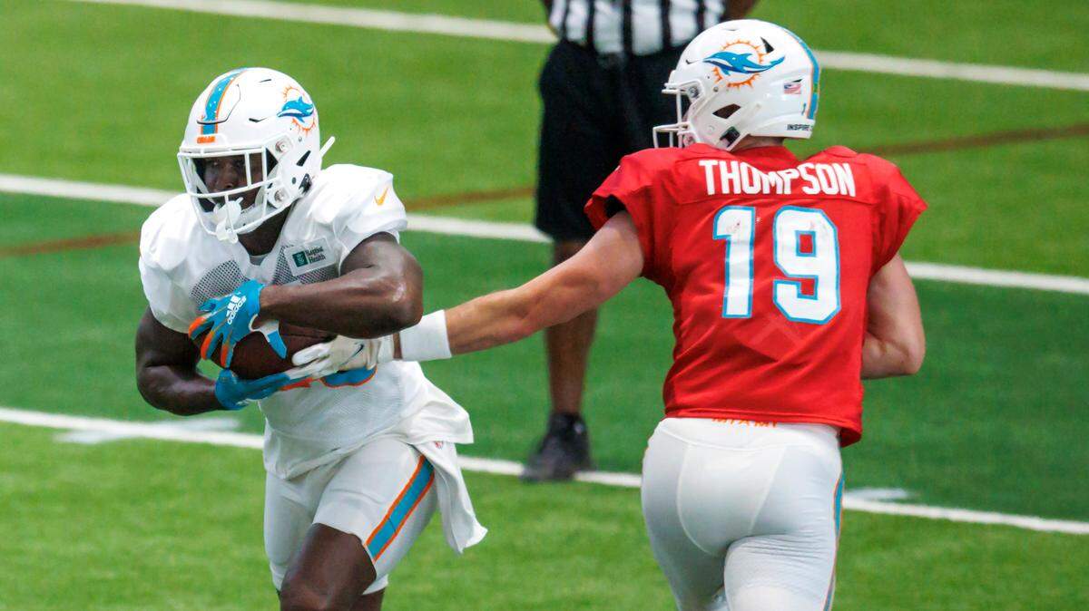 Miami Dolphins quarterback Skylar Thompson (19) hand off to Dolphins running back Sony Michel (28) during NFL football training camp at Baptist Health Training Complex in Hard Rock Stadium on Thursday, August 18, 2022 in Miami Gardens, Florida.