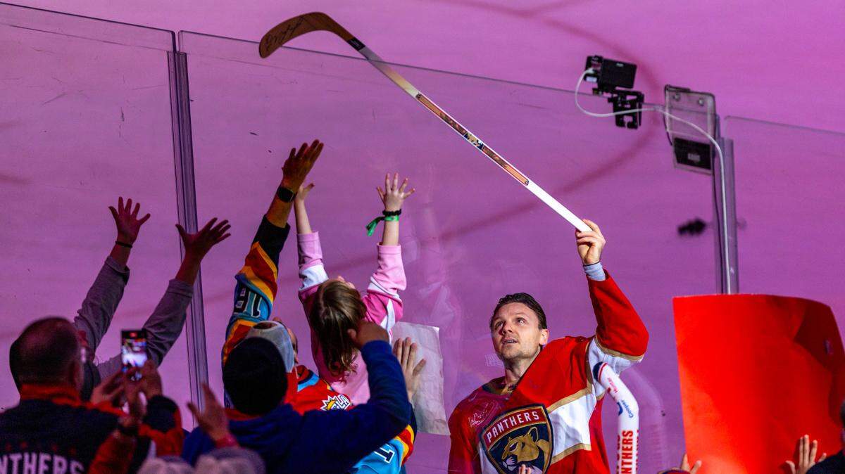 Florida Panthers center Sam Reinhart (13) gives a young fan a hockey stick after his team defeated the New York Rangers during an NHL game at Amerant Bank Arena in Sunrise, Florida, on Friday, December 29, 2023.