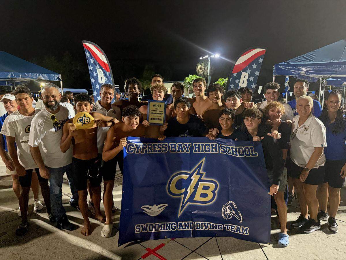 Cypress Bay’s boys’ swimming and diving team celebrates after winning the BCAA championship on Saturday night at the Plantation Aquatic Center in Plantation, Fla.