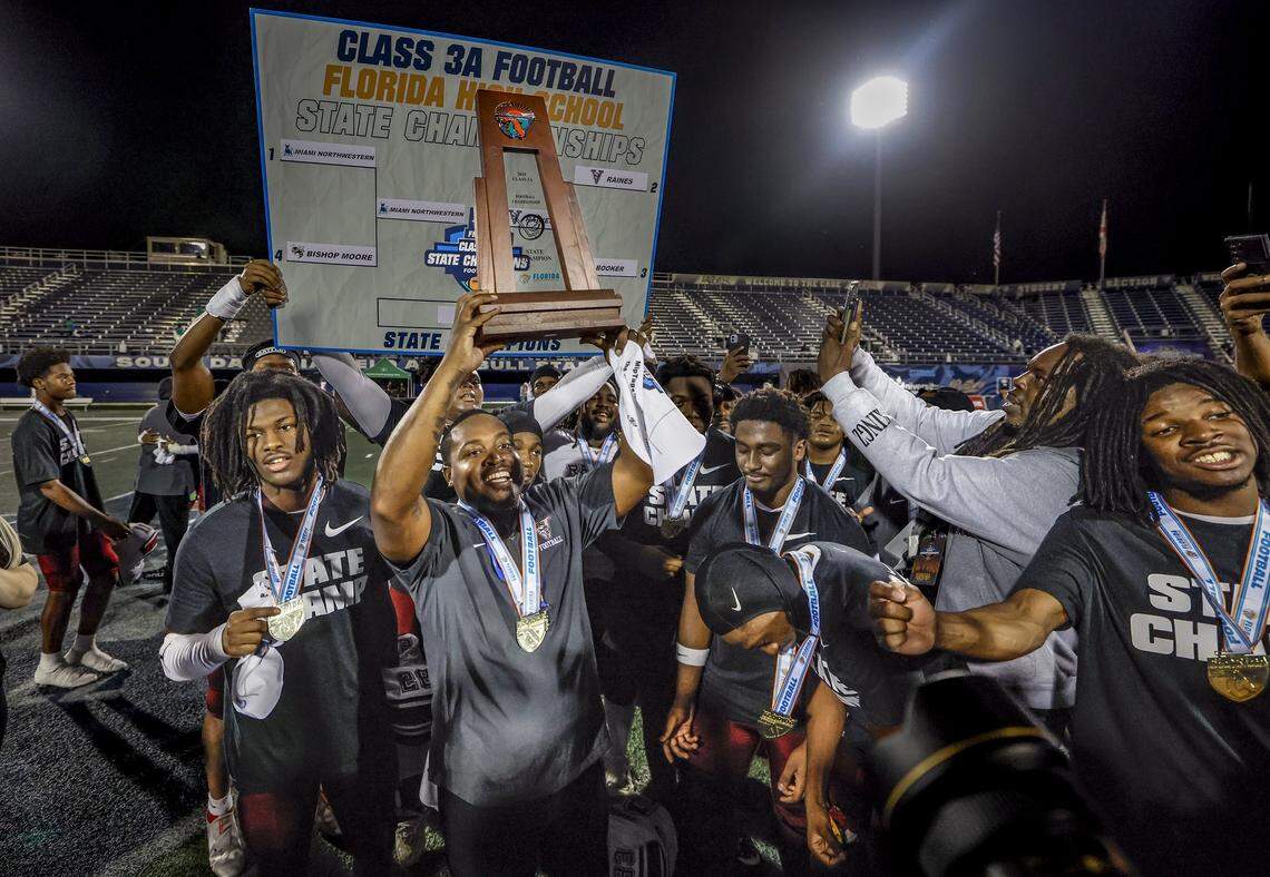 Raines Vikings head football coach Donovan Masline hoists the FHSAA Class 3A State Championship trophy after defeating the Miami Northwestern Bulls at FIU's Pitbull Stadium in Miami, Florida on Saturday, December 13, 2025.