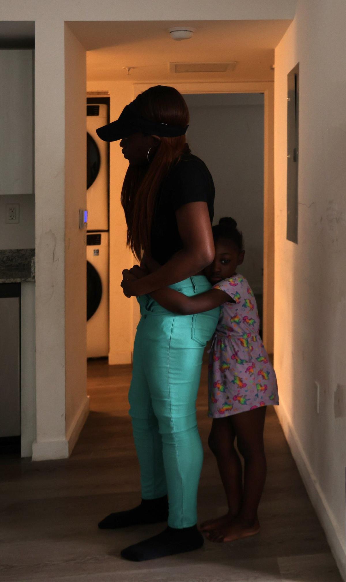 Resident Cheyenne Duncan is held closely by her daughter, Queen, as she describes the recurring mold in her unit at Liberty Square, which she says has affected her daughter’s health. About 226 residents of the former Liberty Square public housing project have moved into the new properties in phases 1-3, according to the Related Group.