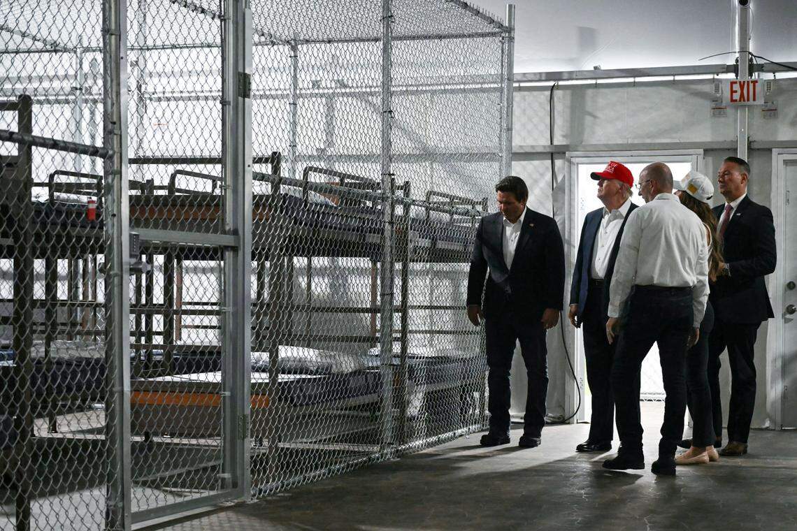 US President President Donald Trump (2L), alongside Florida Governor Ron DeSantis (L), tour a migrant detention center, dubbed “Alligator Alcatraz,” located at the site of the Dade-Collier Training and Transition Airport in Ochopee, Florida on July 1, 2025. President Trump is visiting a migrant detention center in a reptile-infested Florida swamp dubbed “Alligator Alcatraz.” Trump will attend the opening of the 5,000-bed facility -- located at an abandoned airfield in the Everglades wetlands -- part of his expansion of deportations of undocumented migrants, his spokeswoman said. (Photo by ANDREW CABALLERO-REYNOLDS / AFP) (Photo by ANDREW CABALLERO-REYNOLDS/AFP via Getty Images)
