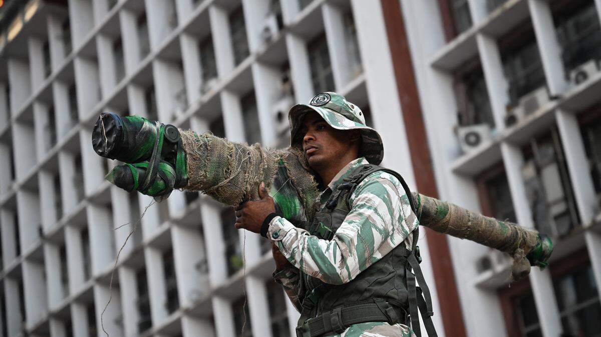 A member of the Bolivarian National Militia holds a Russian-made 9K338 "Igla-S" (SA-18) man-portable air-defense (MANPAD) surface-to-air missile launcher as he takes part in a rally against US military activity in the Caribbean, in Caracas on October 30, 2025. A US guided-missile destroyer that docked for four days in Trinidad and Tobago, within firing range of mainland Venezuela -- which called its presence a "provocation" -- departed as scheduled on Thursday, AFP witnessed. 