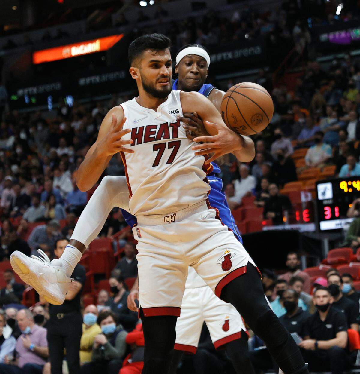 Miami Heat center Omer Yurtseven (77) battle for a loose ball against Dallas Mavericks guard Frank Ntilikina (21) during the second quarter of their NBA basketball game at the FTX Arena on Tuesday, February 15, 2022 in Miami, Fl.