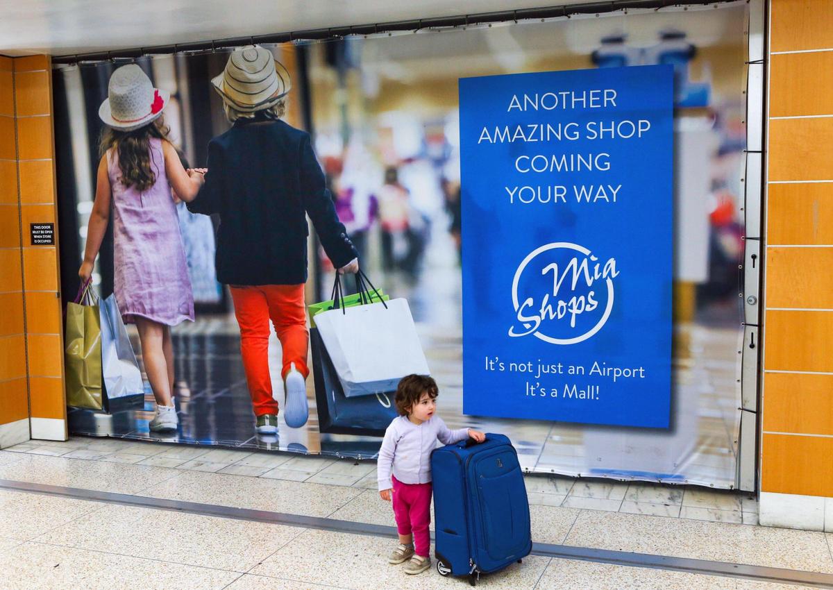 Baltimore native Naomi Peth, 2, hangs onto her mother’s luggage while standing in front of a closed shop at Miami International Airport in Miami, Florida, on Monday, November 22, 2021.