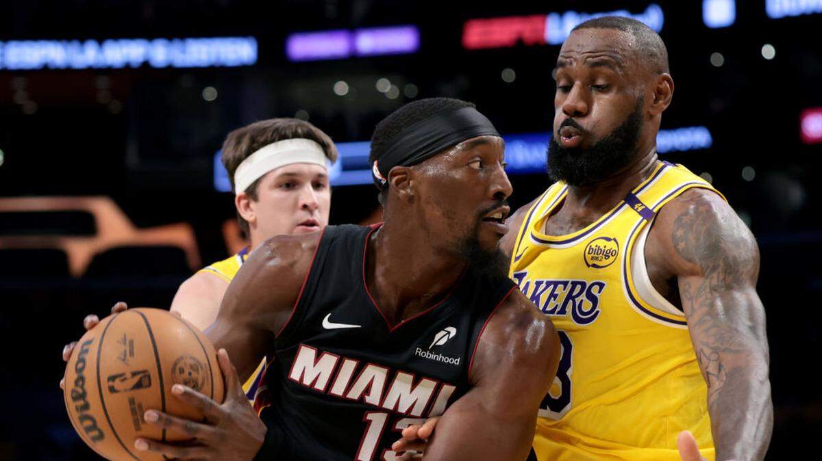 Bam Adebayo #13 of the Miami Heat keeps the ball from LeBron James #23 and Austin Reaves #15 of the Los Angeles Lakers during the first half at Crypto.com Arena on January 15, 2025 in Los Angeles, California.