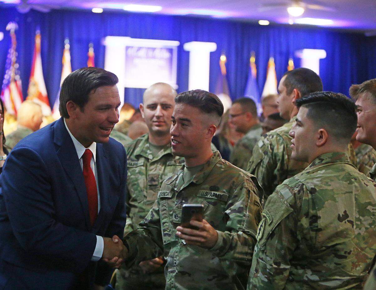El gobernador electo de la Florida, Ron DeSantis, saluda a los soldados tras anunciar una donación de $150,000 a la Operación 300, que organiza campamentos de aventura para niños que han perdido a sus padres en combate. La ceremonia, 'Una llamada a la acción', rindió homenaje a los miembros de las fuerzas armadas y a los socorristas, el 7 de enero de 2019, en Tallahassee.