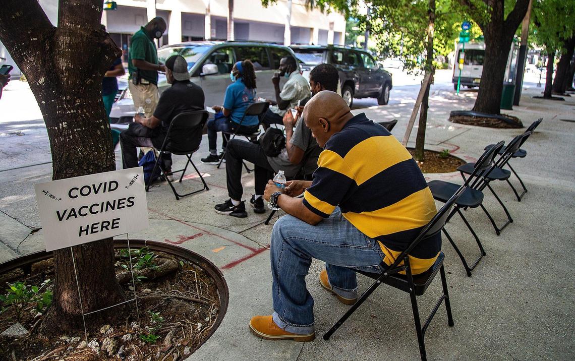 A group of homeless living in downtown Miami are kept under observation for 30 minutes at s mobile COVID-19 vaccination spot for Miami’s homeless on Flagler Street after getting vaccinated with the (J&J/Janssen) COVID-19 vaccine.
