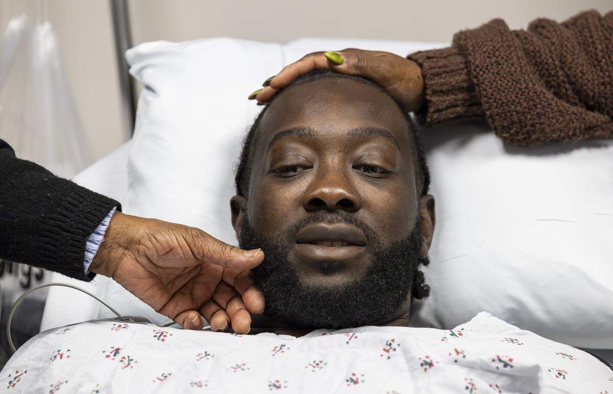 Chevon Byfield, 39, who suffers from heart failure and relies on a left ventricular assist device (LVAD), is consoled by his grandmother, Brylon Brown, left, and his mother, Sharon Brown, before heading to his procedure at Memorial Regional Hospital on Tuesday, Feb. 3, 2026, in Hollywood, Fla. After waiting more than six years for a transplant, Byfield checked into the hospital for the fourth time Tuesday to undergo a quarterly procedure and remain on-site until a compatible heart becomes available.