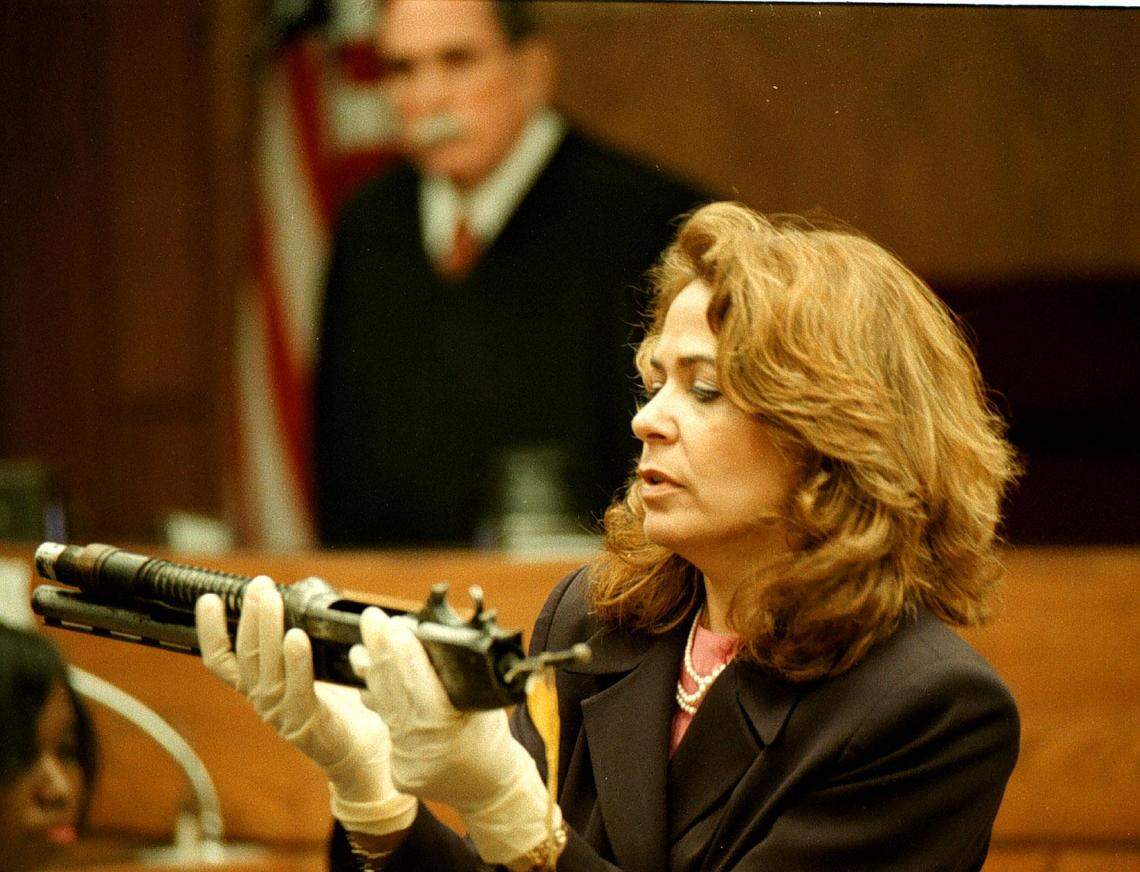 Assistant state attorney Flora Seff displays the broken shotgun during the 1998 murder trial of Labrant Dennis while Judge Manny Crespo looks on.