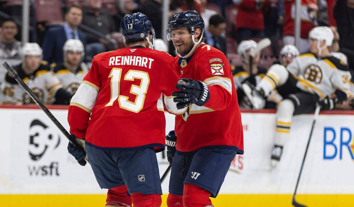Florida Panthers center Sam Reinhart (13) celebrates with defenseman Dmitry Kulikov (7) after scoring a goal against Boston Bruins goaltender Jeremy Swayman (1) in the third period of their NHL game at Amerant Arena on Saturday, Jan. 11, 2025, in Sunrise, Fla.