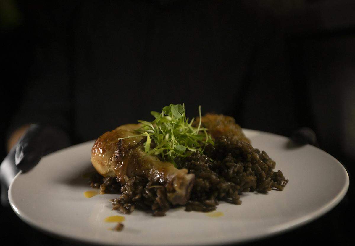 Roasted Epis Chicken served with vegetable légume and djon djon rice, part of a celebration of Fet Gede, the Haitian Day of the Dead, at The Vegan Marie in Little Haiti on Nov. 8, 2025.