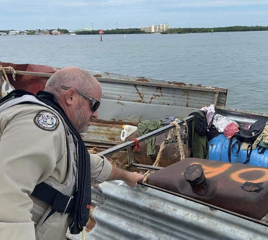 Florida Fish and Wildlife Conservation Commission Officer Jason Rafter inspects a Cuban migrant boat floating on the ocean side of Tavernier Creek in the Florida Keys Friday, Oct. 14, 2022.