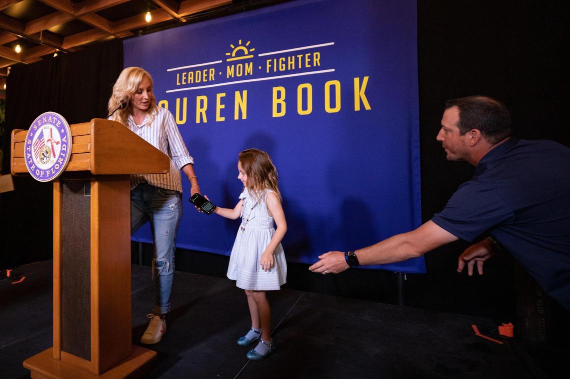 Lauren Book is given her phone with notes by her daughter on stage at her victory party at Agave Bandido restaurant in Pembroke Pines, Florida on election night, Tuesday, August 23, 2022.