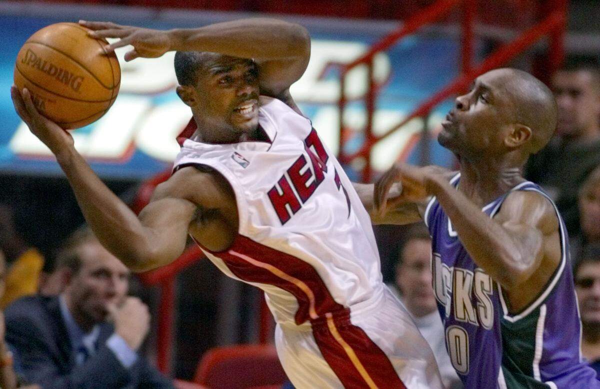 Miami Heat guard Mike James, left, attempts to pass past Milwaukee Bucks’ guard Gary Payton during the second quarter Monday, March 31, 2003 in Miami.
