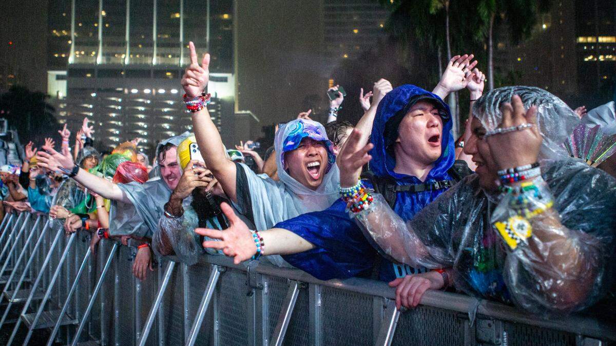 Festival goers react to the rain during a set by Tiesto on Main Stage during Ultra 2024 at Bayfront Park in Downtown Miami on Friday, March 22, 2024.