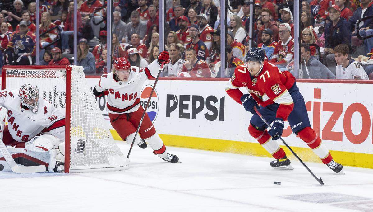 Florida Panthers defenseman Niko Mikkola (77) looks to pass the puck as Carolina Hurricanes goaltender Pyotr Kochetkov (52) and right wing Jackson Blake (53) defend in the first period of Game 3 during the Eastern Conference final of the NHL Stanley Cup playoffs at Amerant Bank Arena on Saturday, May 24, 2025, in Sunrise, Fla.