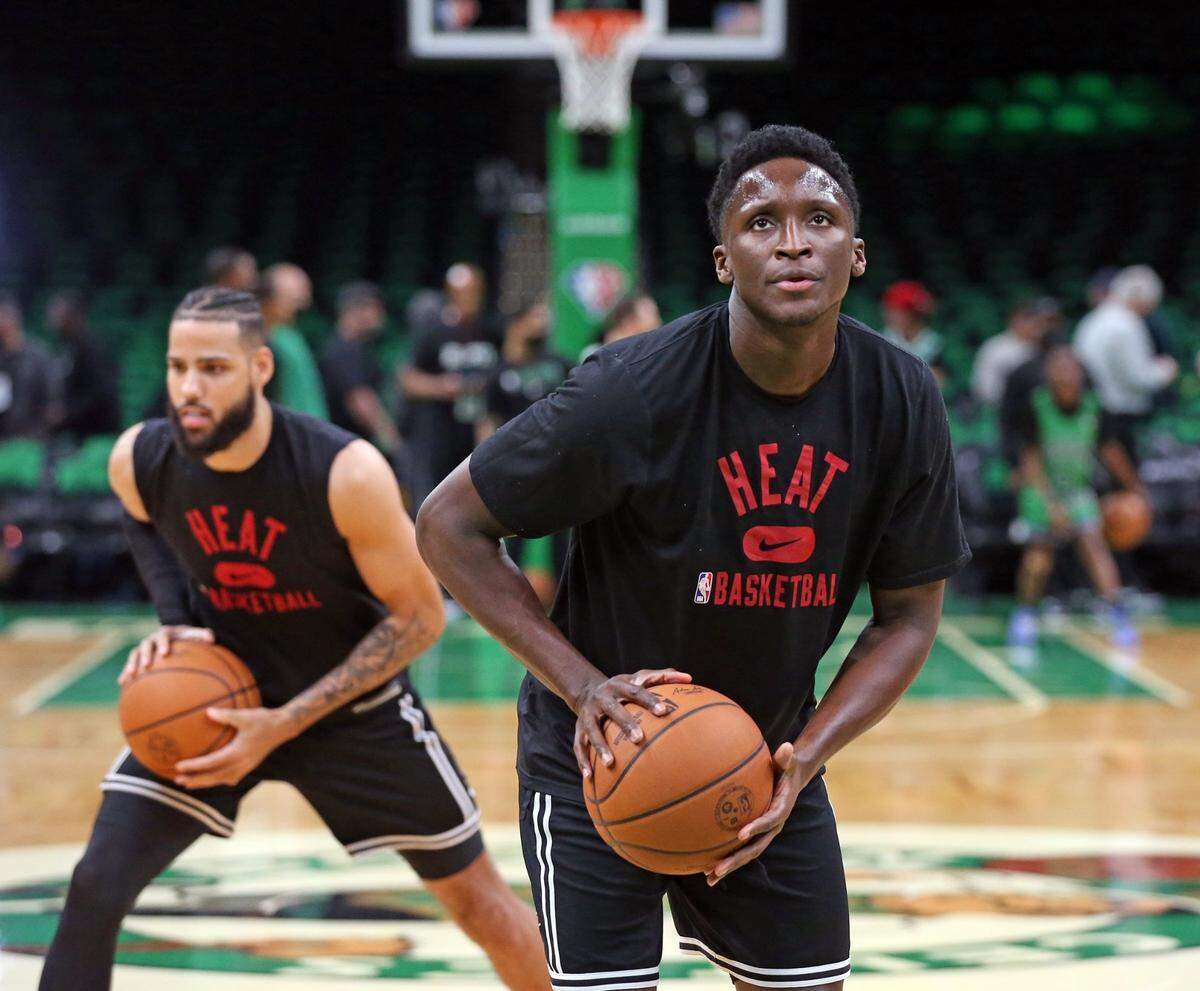 Miami Heat guard Victor Oladipo (4) and forward Caleb Martin (16), at left, warm up before the start of Game 4 of the Eastern Conference Finals at TD Garden in Boston on May 23, 2022.