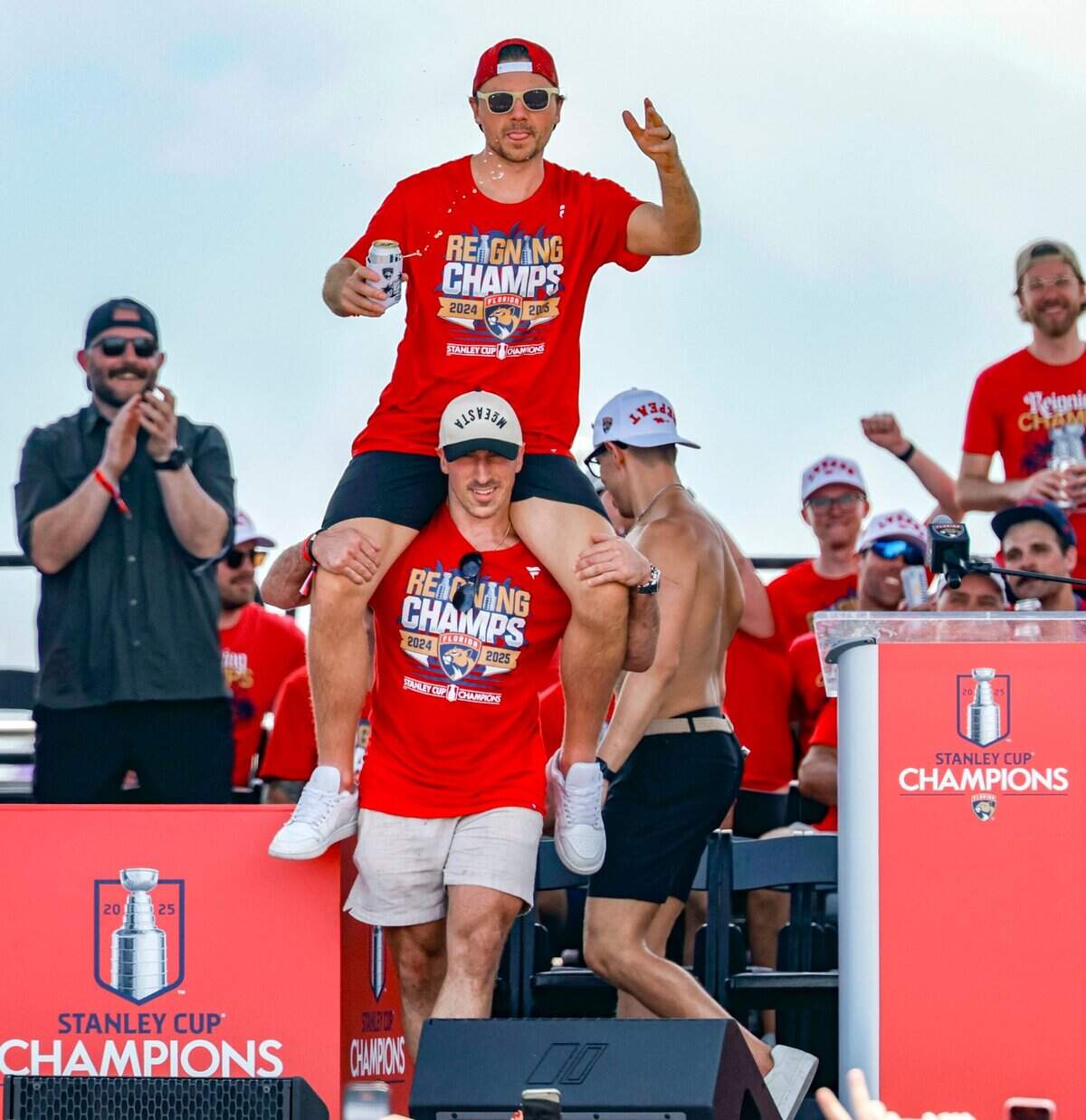 Florida Panthers center Sam Reinhart rides on the shoulders of teammate Brad Marchand as they celebrate on stage with the team during the Stanley Cup victory parade and rally along A1A in Fort Lauderdale, Florida, on Sunday, June 22, 2025.
