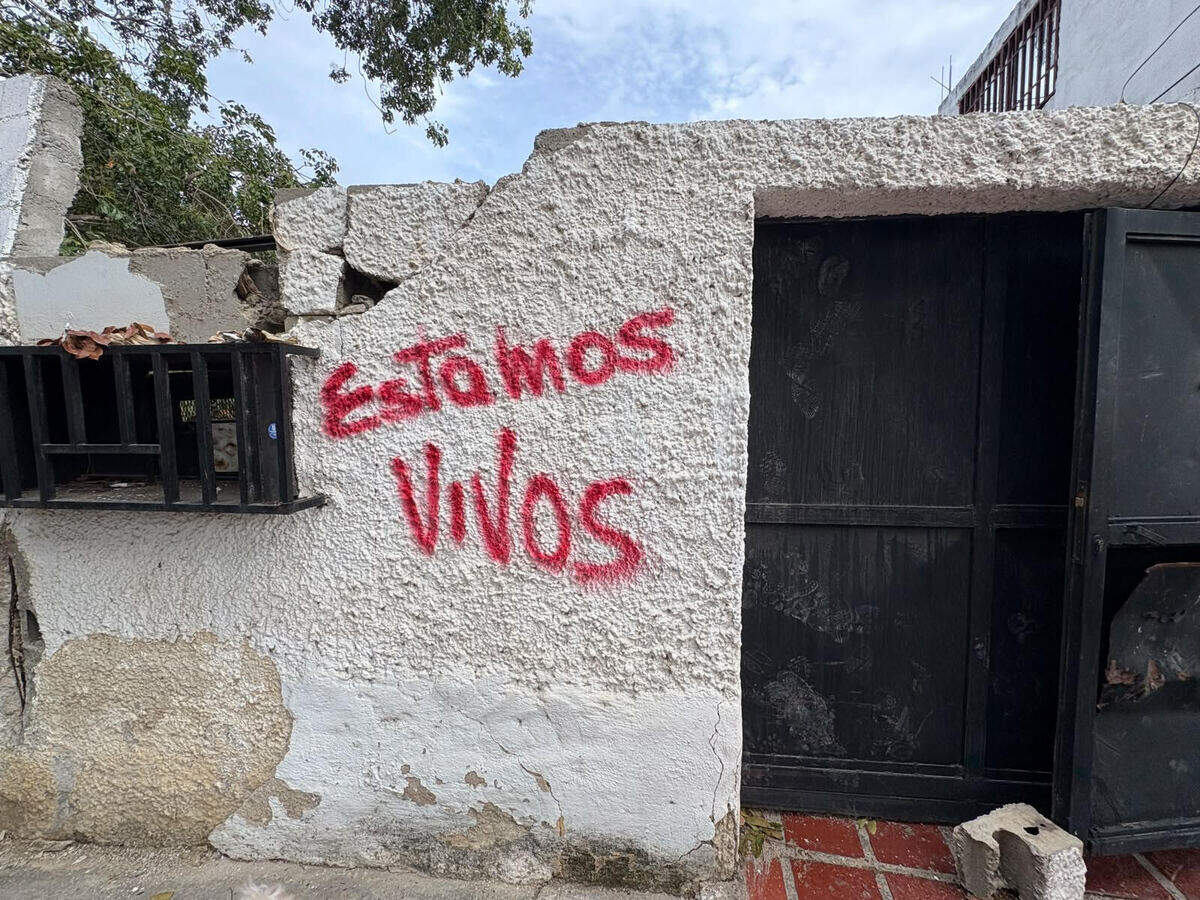 “Estamos Vivos” — We are Alive — painted on the side of Daniel Tavares’ house in La Guaira.