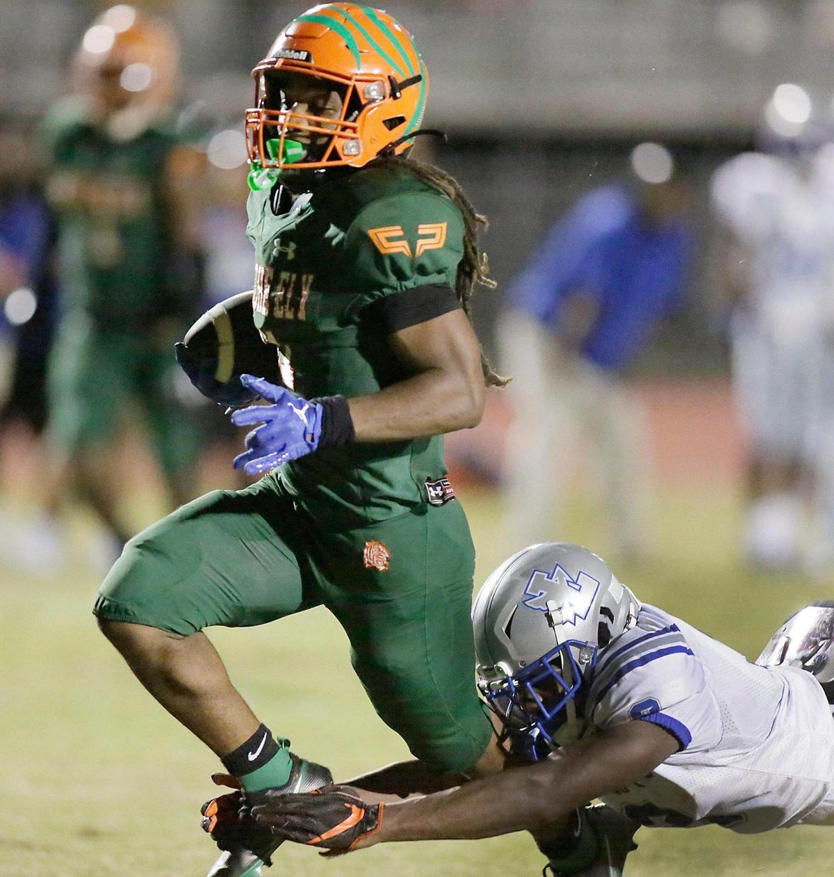 Blanche Ely Tigers running back Cedric Ward (11) tries to break free from Fort Lauderdale Flying L’s defender during football game on Friday, September 30, 2022 at Blanche Ely HS in Pompano Beach. Andrew Uloza / for Miami Herald