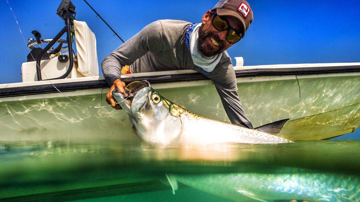 Capt. Grif Helwig of Key West with a tarpon at the side of his flats boat before releasing the fish.