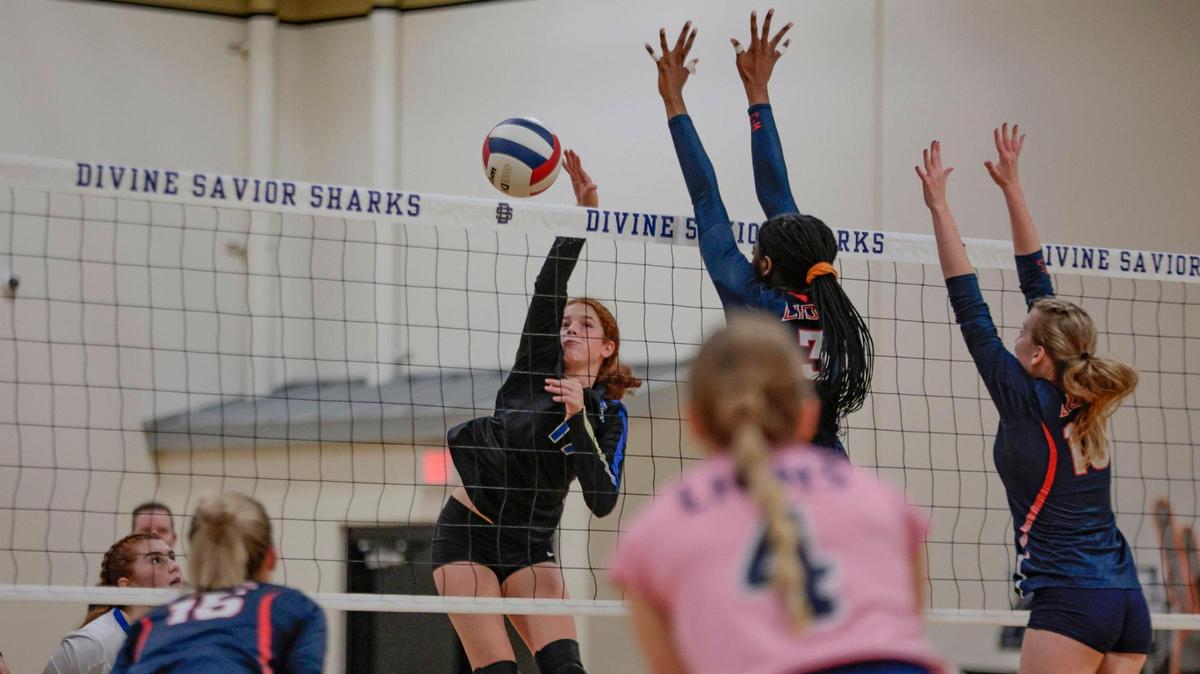 Divine Savior volleyball player Sasha Kawas (17) spikes the ball as Chaminade-Madonna’s Kendall Evans (3) and Lara Zima (10) defend at the net during the Region 4-3A semifinal volleyball playoff at Divine Savior Academy on Friday, October 28, 2022.