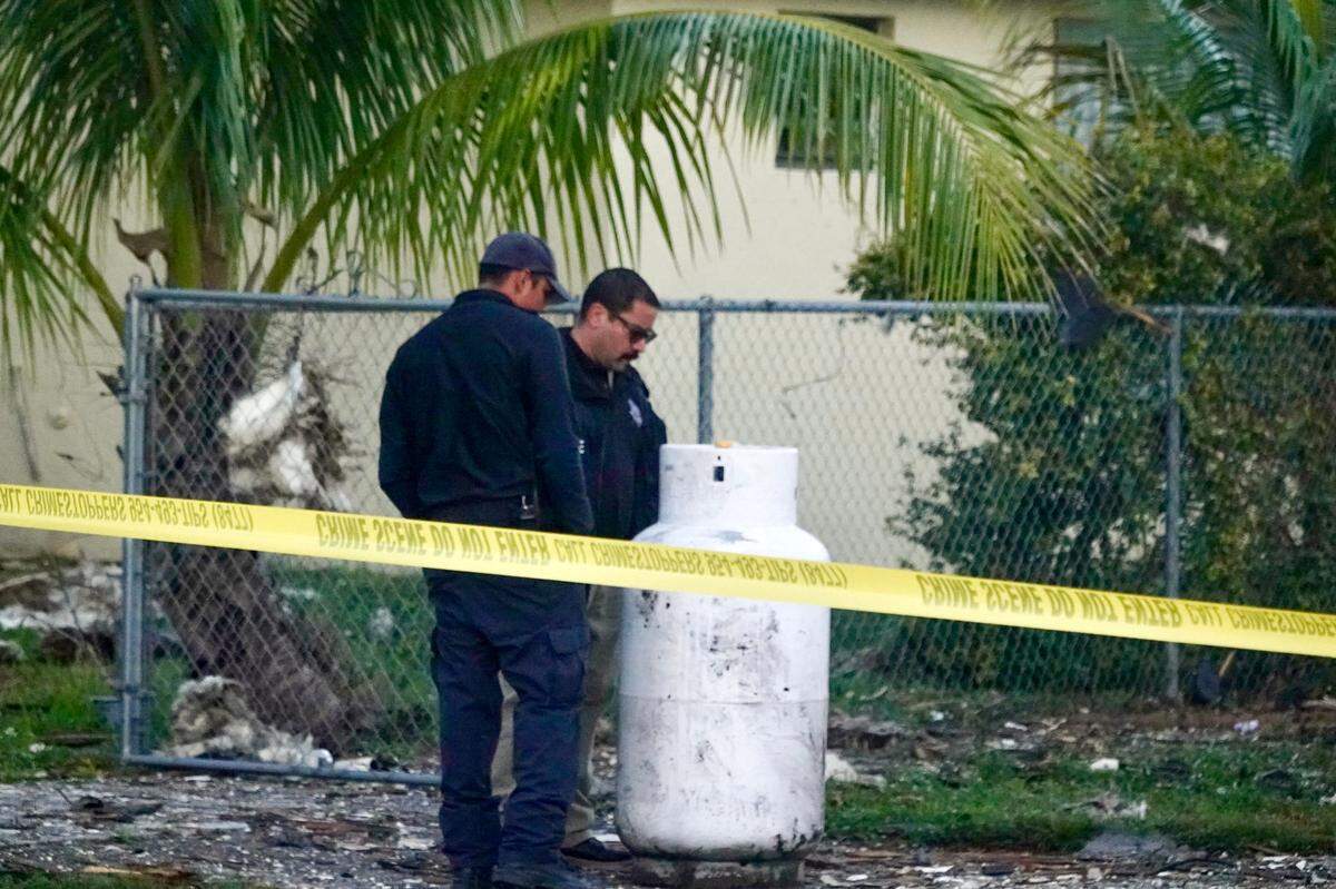 Firefighters investigate a house explosion in West Park, Florida, on Tuesday, Dec. 19, 2023.