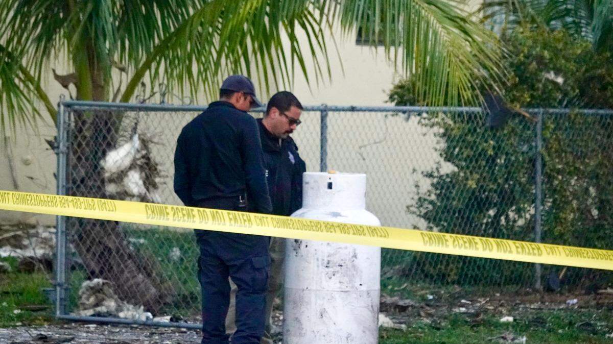 Firefighters investigate a house explosion in West Park, Florida, on Tuesday, Dec. 19, 2023.