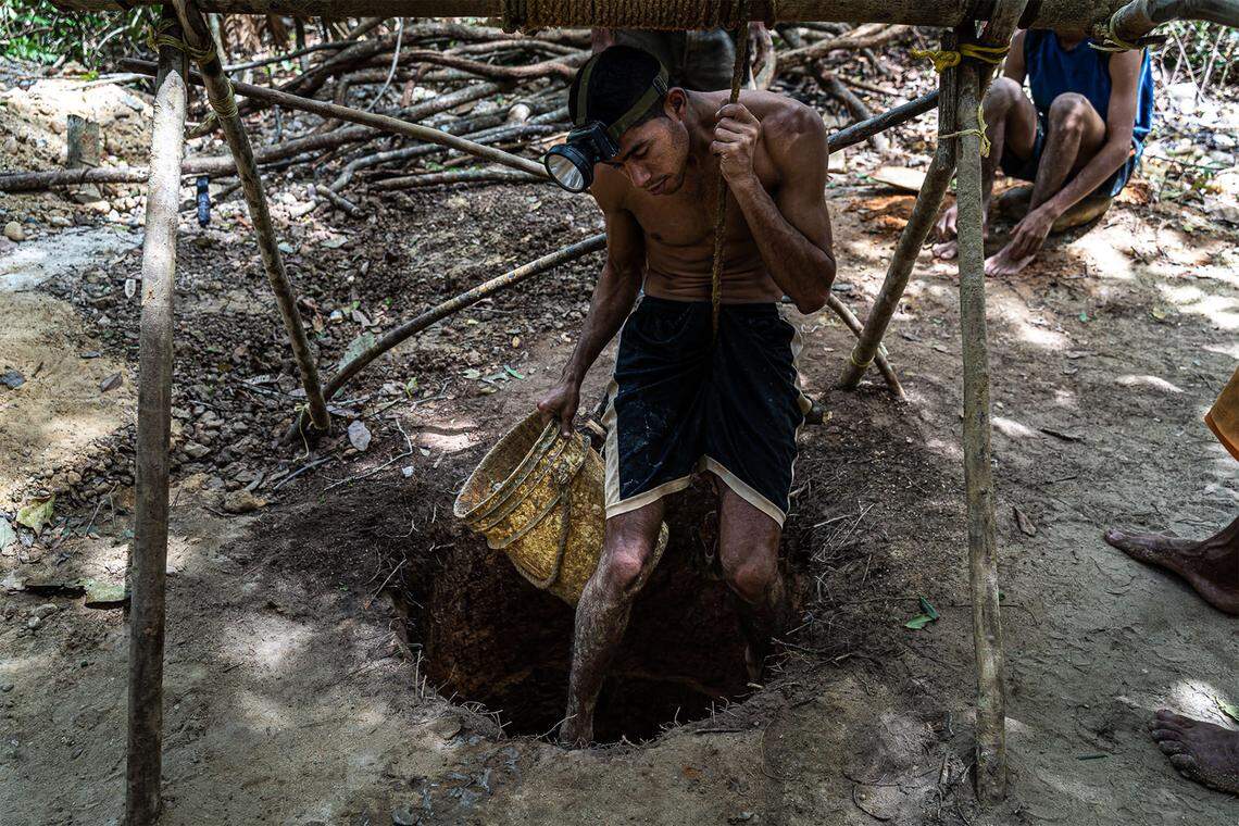 Using a rope, a miner prepares to descend into the earth in Tumeremo, Venezuela. The work is not only dirty and dangerous — thanks, in part, to the use of toxic mercury to separate gold from plain rock — but it endangers those in surrounding communities by poisoning rivers and the fish that inhabit them.